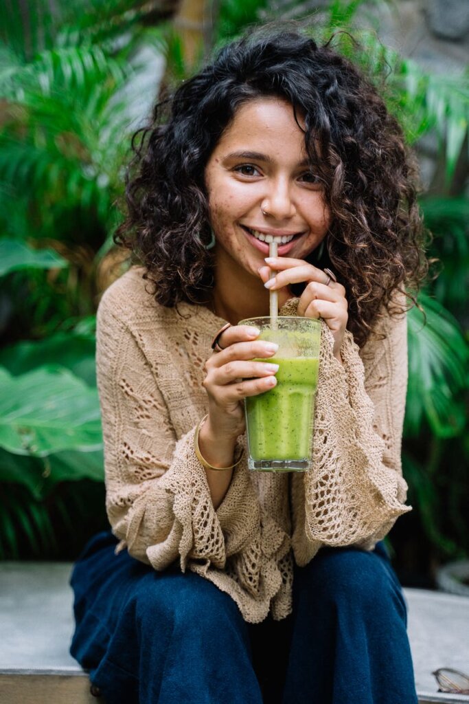 woman in beige knitted sweater holding a healthy drink